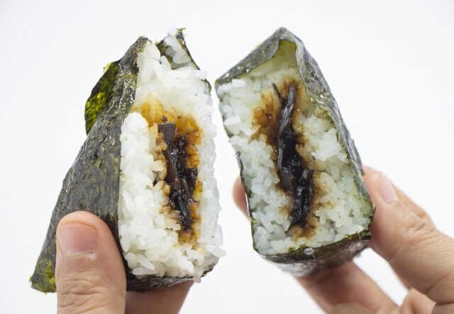 手で割ったおにぎりの中から、昆布の具材が見えている写真。のりで巻かれた手作り風。