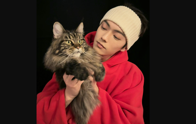 シューカイが、自宅で飼い猫を抱き上げる様子